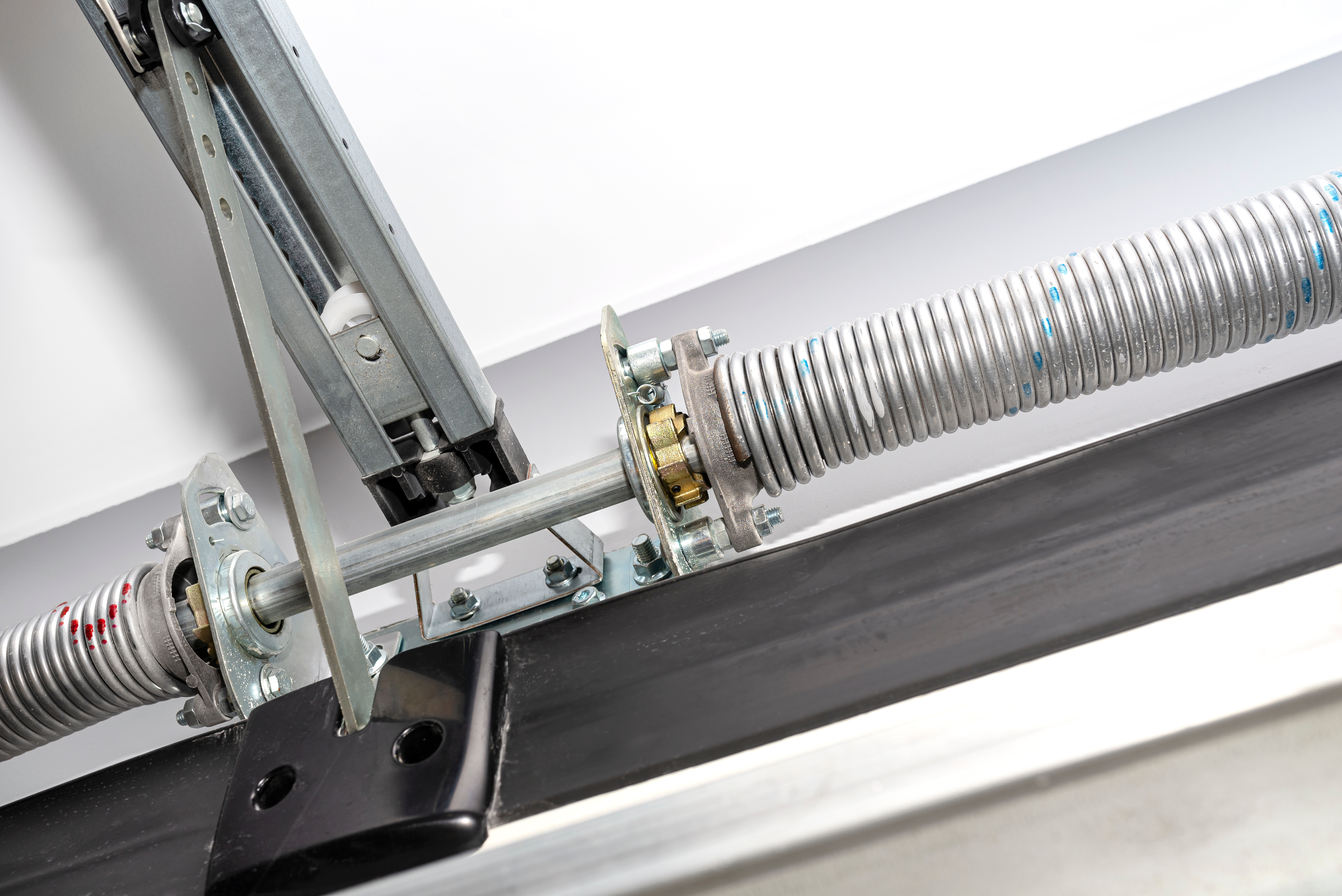 Close-up of torsion spring and mounting hardware on garage door